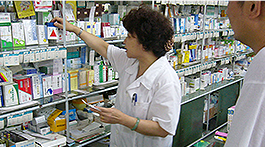Staff in the pharmacy reaching for medicine at the counter